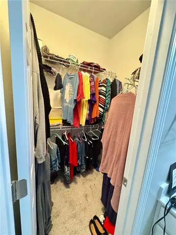 a view of walk in closet with clothes