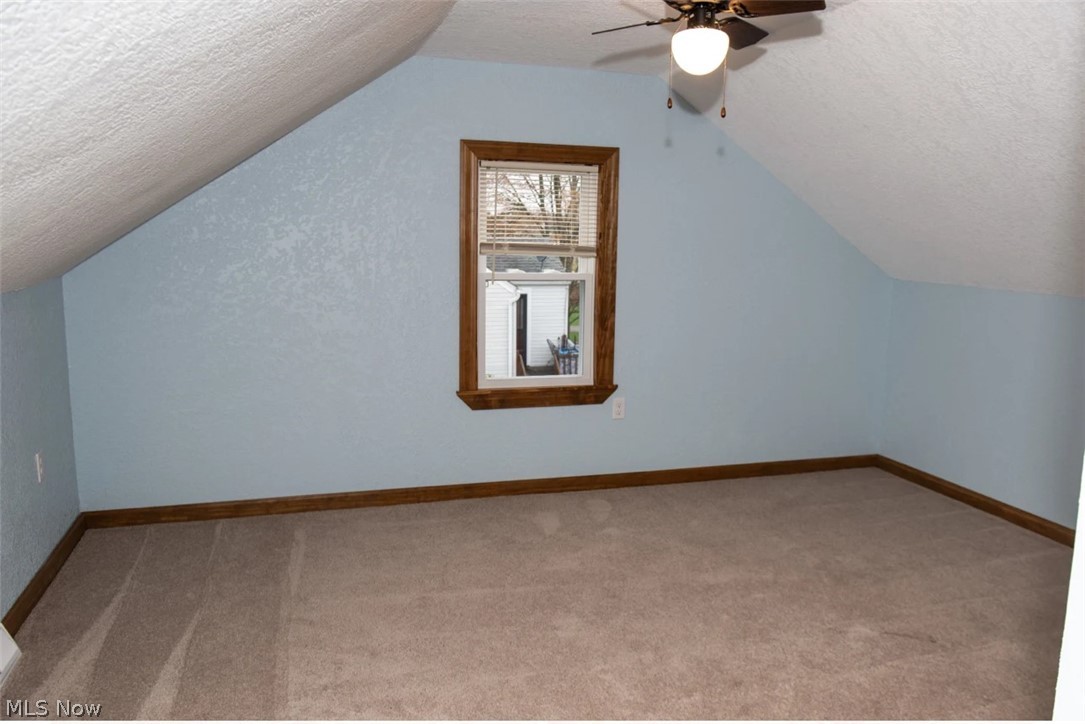 1721 State Road Northwest Warren, OH 44481 - Photo 17 of 37 Bonus room with vaulted ceiling, ceiling fan, carpet floors, and a textured ceiling