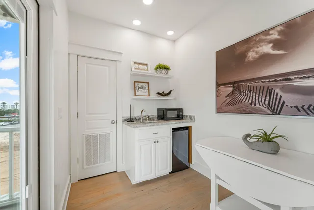 a kitchen with stainless steel appliances granite countertop a stove a sink and a refrigerator with wooden floor