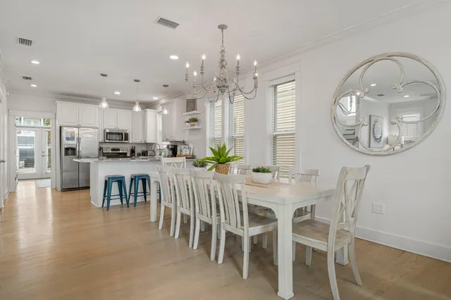 a dining room with furniture a kitchen and chandelier