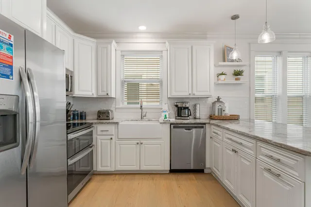 a kitchen with stainless steel appliances granite countertop a sink a stove a refrigerator and cabinets