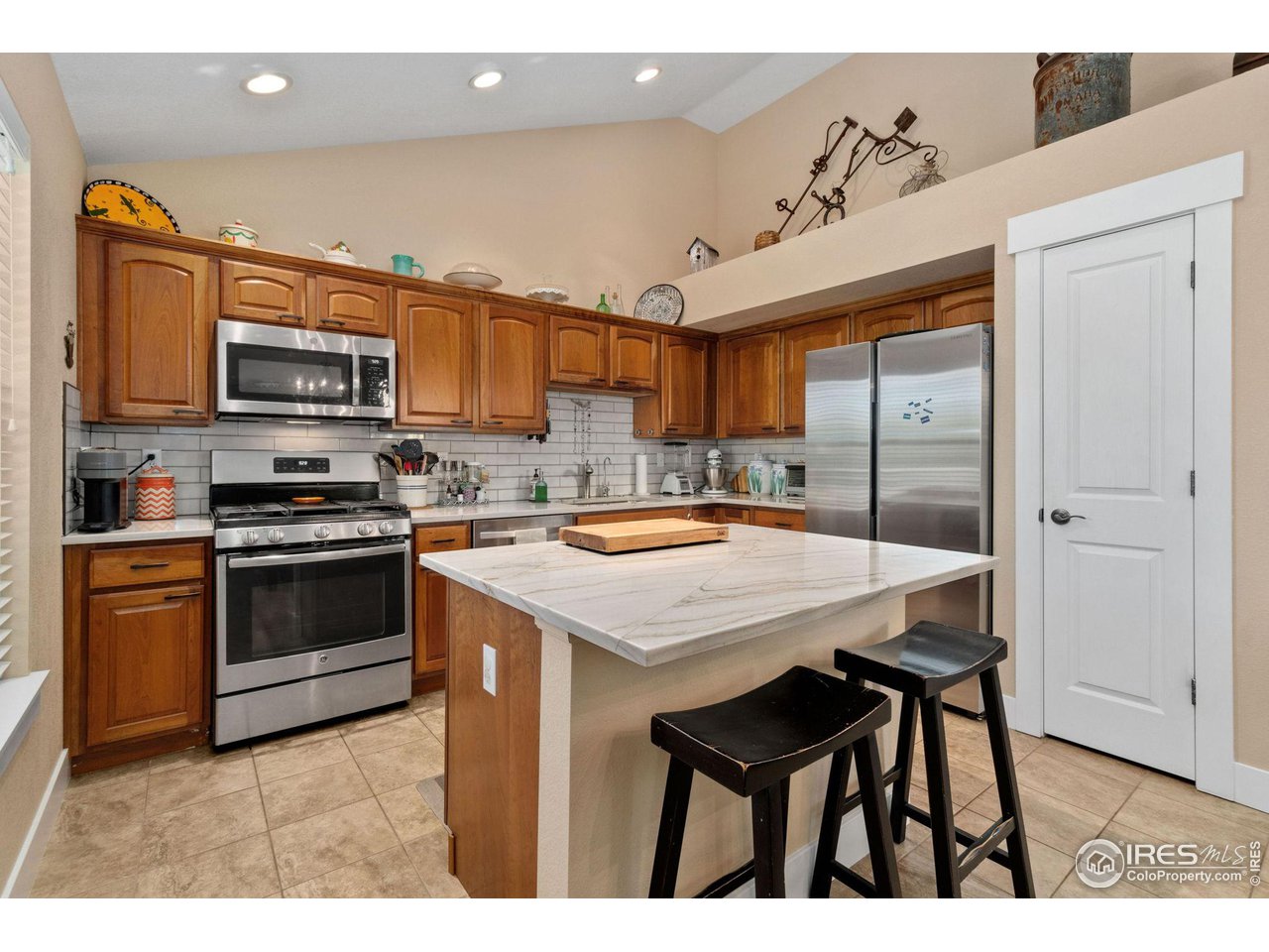 2425 Windrow Lane Lafayette, CO 80026 - Photo 14 of 35 a kitchen with stainless steel appliances granite countertop a stove top oven a sink and a refrigerator