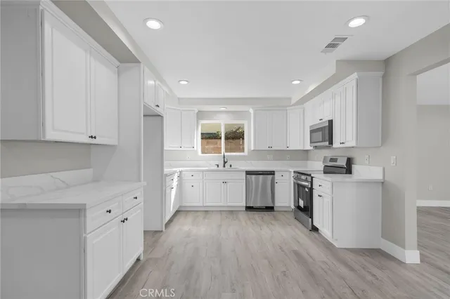 a kitchen with cabinets a sink and wooden floor