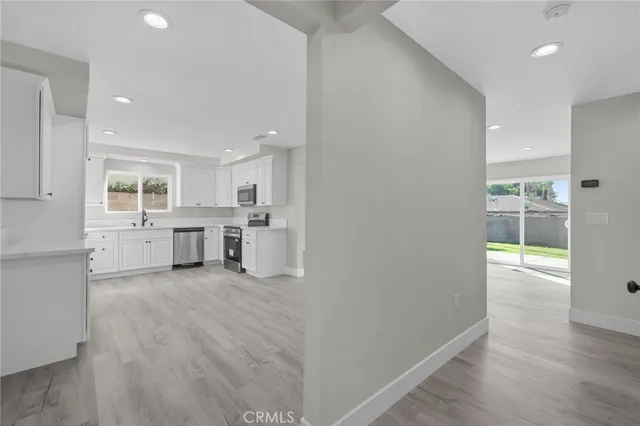 a view of a kitchen with wooden floor and a window