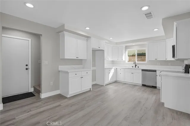 a large kitchen with a lot of counter space and wooden floor