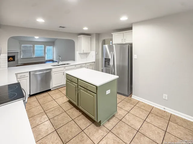 a kitchen with stainless steel appliances granite countertop a refrigerator and a stove top oven