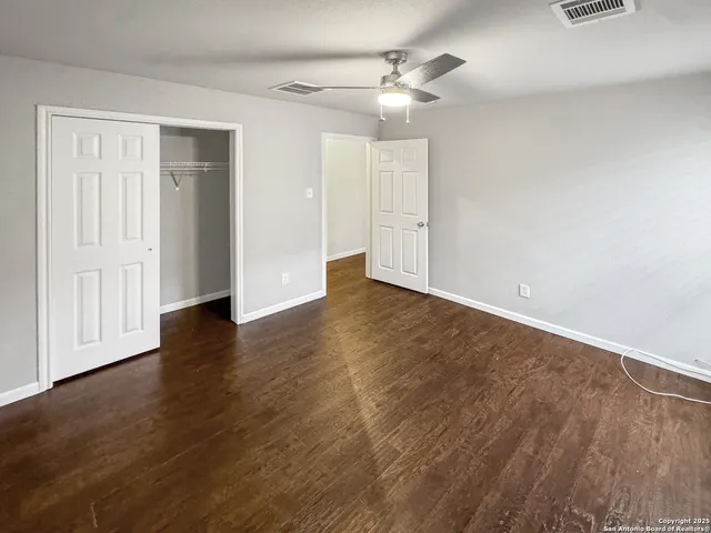 a view of an empty room with wooden floor