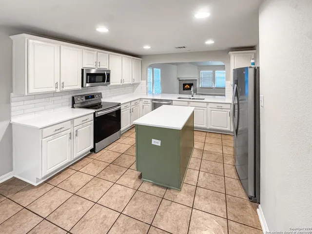 a kitchen with stainless steel appliances granite countertop a refrigerator sink and cabinets