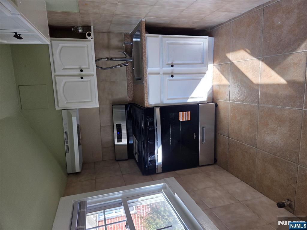 250 Ridgefield Avenue, Unit 2 Bogota, NJ 07603 - Photo 4 of 9 a kitchen with stainless steel appliances granite countertop a stove a microwave and a refrigerator