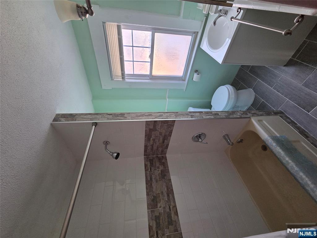 250 Ridgefield Avenue, Unit 2 Bogota, NJ 07603 - Photo 5 of 9 a bathroom with a sink toilet a shower and bathtub