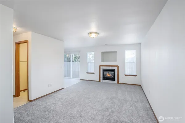 an empty room with fireplace and window
