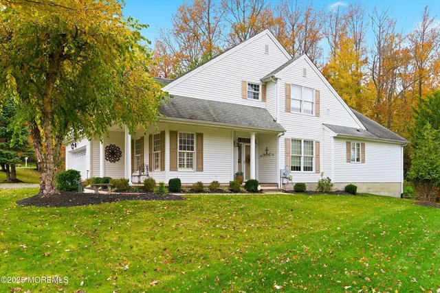 a front view of a house with a yard and trees