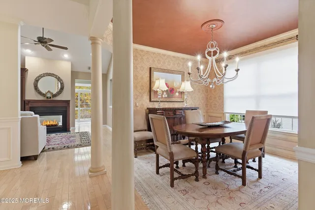 a view of a dining room with furniture a chandelier and wooden floor