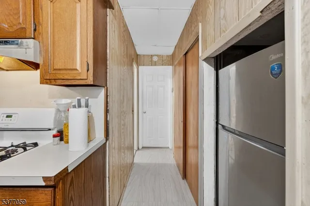a view of storage and utility room with stainless steel appliances granite countertop refrigerator and a sink