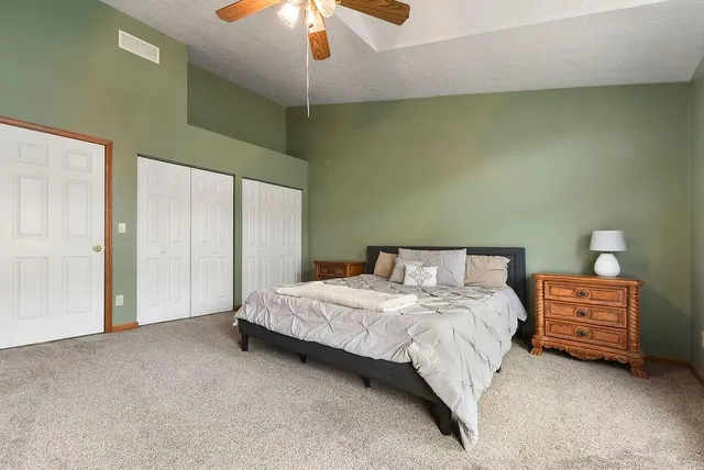 a bedroom with a bed dresser and a chandelier