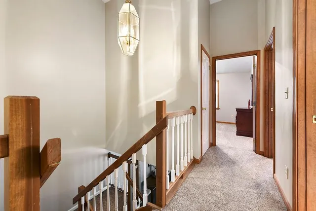 a view of a hallway with wooden floor and stairs