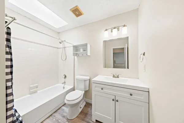 a bathroom with a sink toilet vanity and shower