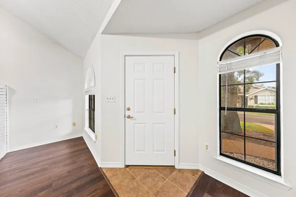 an empty room with wooden floor and mirror