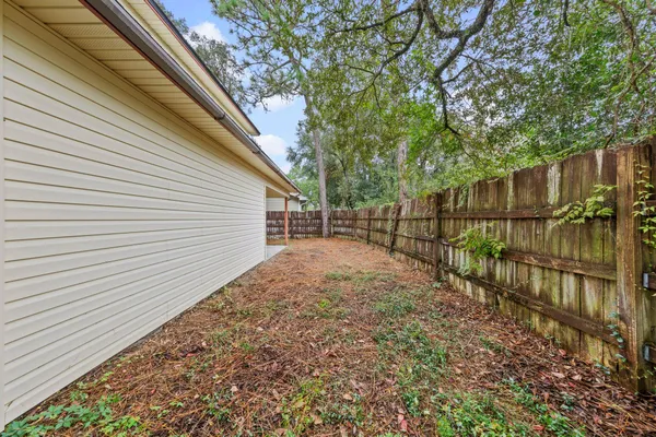 a view of a house with a small yard and wooden fence