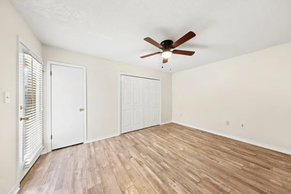 an empty room with wooden floor and windows