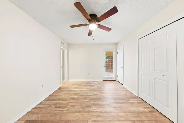 a view of empty room with wooden floor