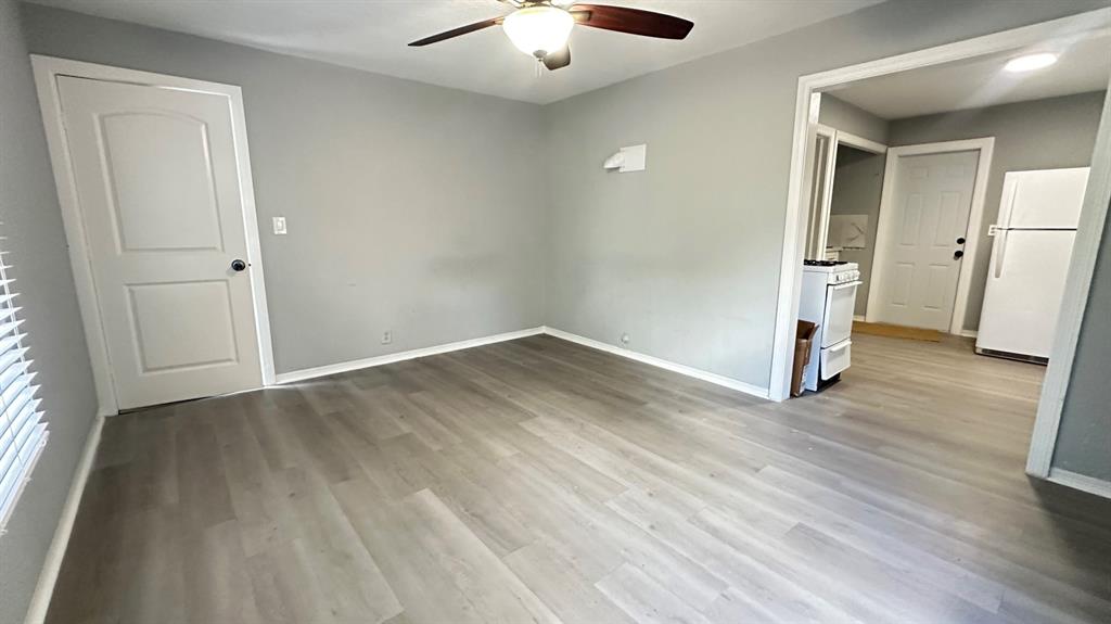 an empty room with wooden floor and window