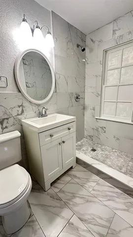 a bathroom with a toilet sink and mirror