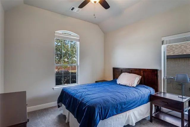 a bedroom with a large bed and a chandelier
