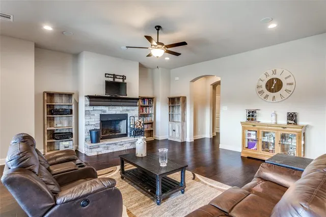 a living room with furniture a flat screen tv and a fireplace
