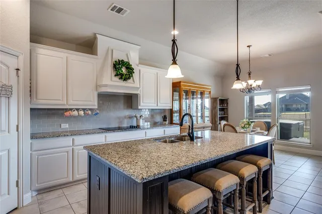 a kitchen with granite countertop kitchen island a table and chairs in it