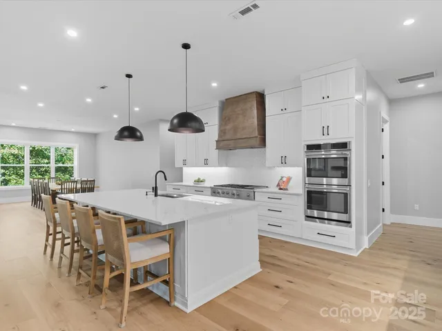 a large kitchen with stainless steel appliances kitchen island granite countertop a sink and cabinets