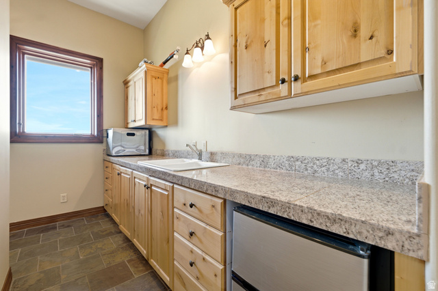 335 Bern Way Midway, UT 84049 - Photo 44 of 88 Utility space featuring wood-finish cabinetry, granite-style countertops, an integrated sink, and an under-counter refrigerator