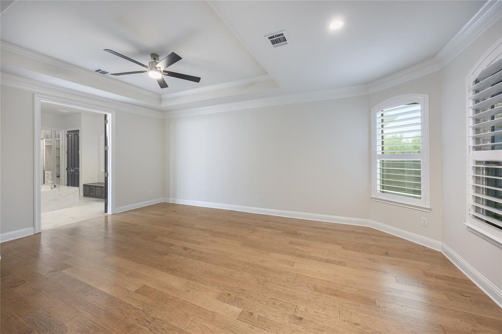 918 Sydney Lane Allen, TX 75013 - Photo 13 of 40 Expansive room featuring hardwood floors, a tray ceiling with a ceiling fan, and two windows with plantation shutters