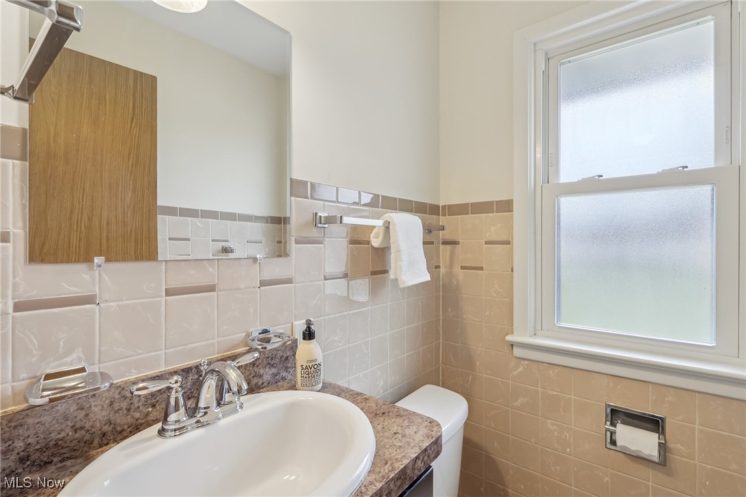 6325 Ranchview Drive Independence, OH 44131 - Photo 6 of 35 Half bath with vanity, tile walls, and toilet