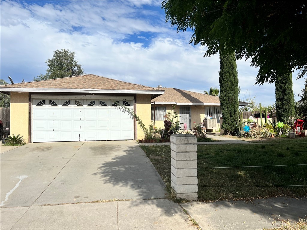 311 North Brampton Avenue Rialto, CA 92376 - Photo 1 of 1 a front view of a house with a yard and garage