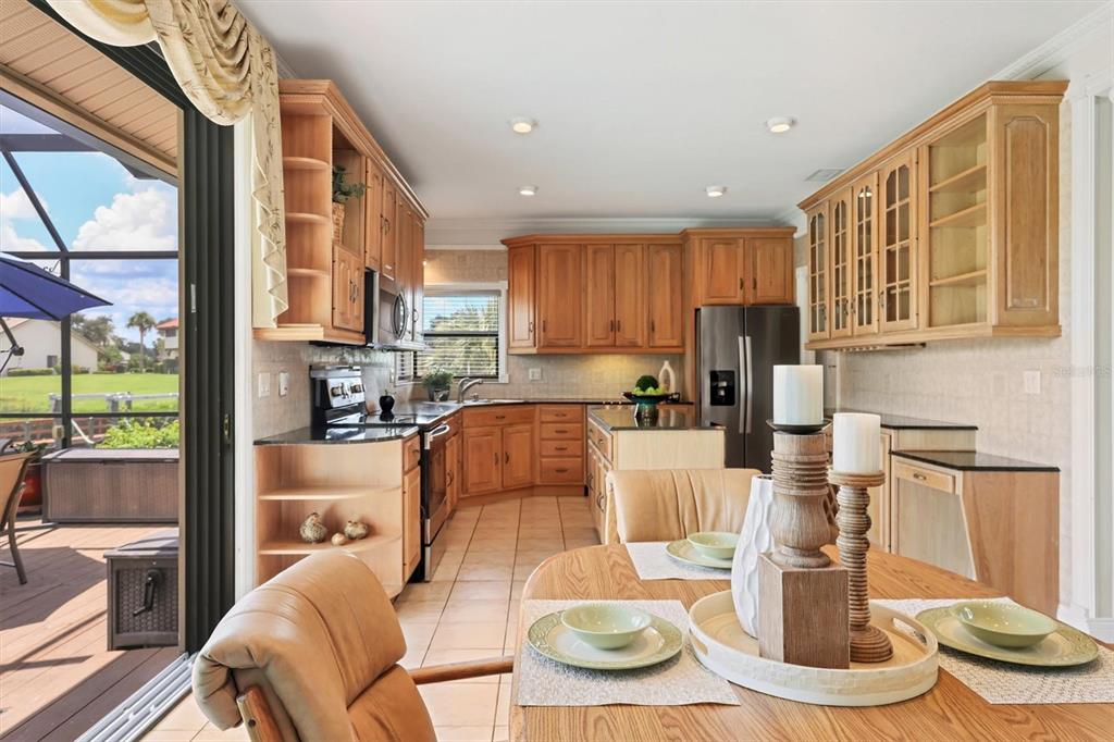 133 Inlets Boulevard, Unit 133 Nokomis, FL 34275 - Photo 17 of 63 a kitchen with stainless steel appliances kitchen island granite countertop a table and chairs