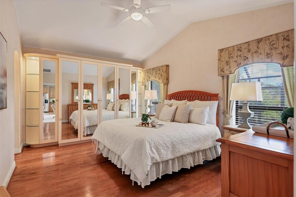 133 Inlets Boulevard, Unit 133 Nokomis, FL 34275 - Photo 18 of 63 a bedroom with a large bed and a chandelier