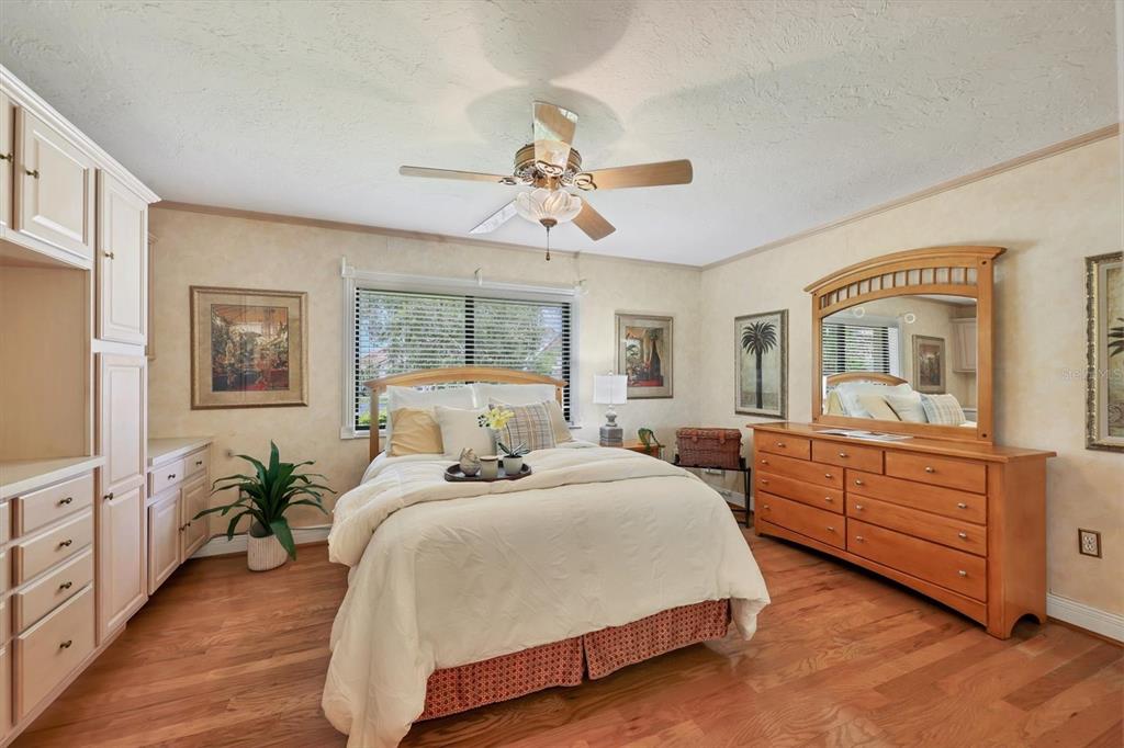 133 Inlets Boulevard, Unit 133 Nokomis, FL 34275 - Photo 23 of 63 a spacious bedroom with a large bed and a chandelier fan
