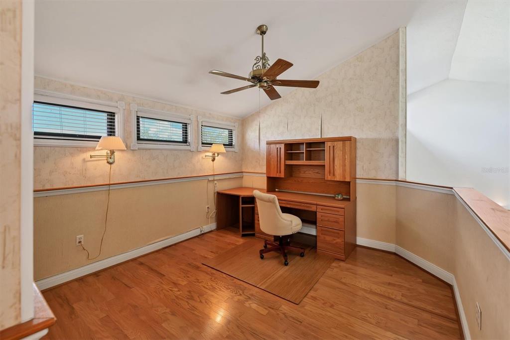 133 Inlets Boulevard, Unit 133 Nokomis, FL 34275 - Photo 27 of 63 a room with wooden floor and white walls