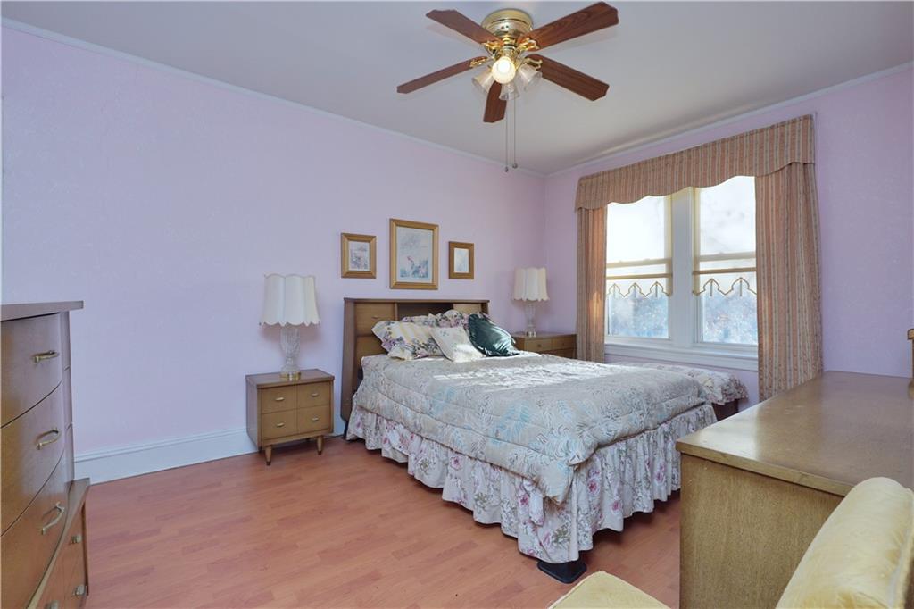649 Bay Ridge Parkway Brooklyn, NY 11209 - Photo 17 of 29 a bedroom with a bed chandelier and a window