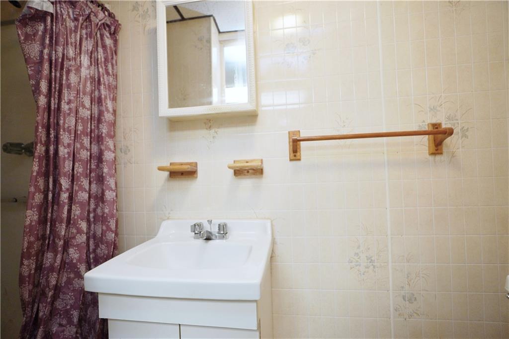 649 Bay Ridge Parkway Brooklyn, NY 11209 - Photo 27 of 29 a bathroom with a sink a mirror and shower curtain
