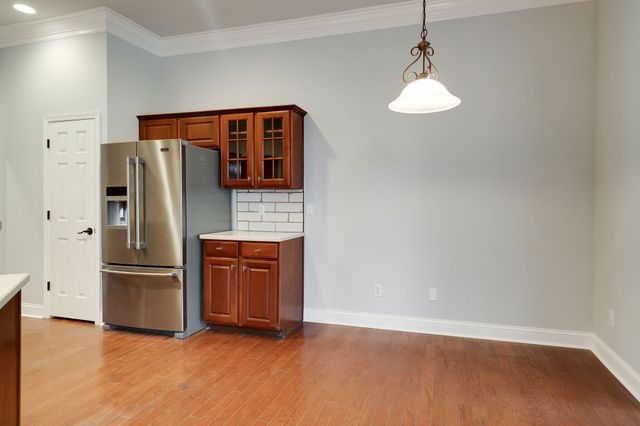 a kitchen with stainless steel appliances granite countertop a refrigerator and a stove top oven