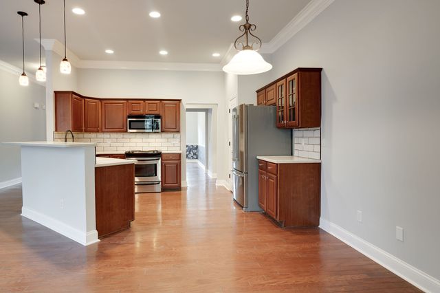 a kitchen with stainless steel appliances granite countertop a refrigerator a stove top oven a sink and dishwasher