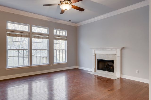 a view of an empty room with exposed radiator and fireplace
