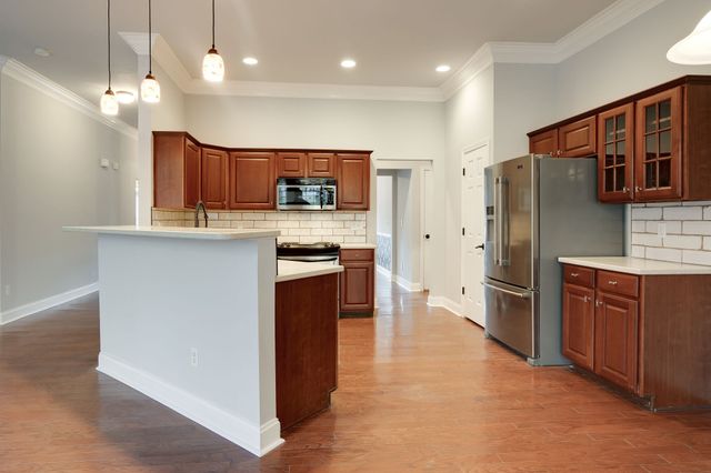 a kitchen with stainless steel appliances granite countertop a refrigerator a stove a sink and a oven