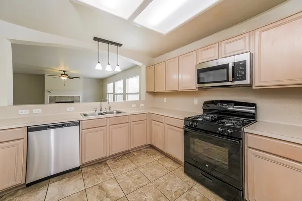 a kitchen with cabinets stainless steel appliances and a sink