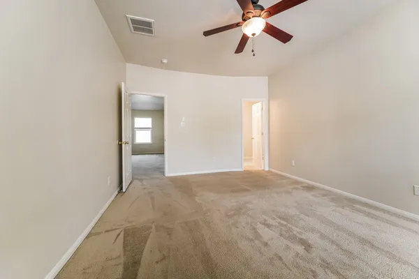 a view of empty room with window and ceiling fan