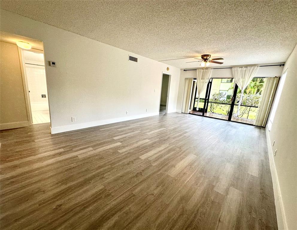159 Northwest 70th Street, Unit 517 Boca Raton, FL 33487 - Photo 8 of 30 a view of an empty room with wooden floor and a window