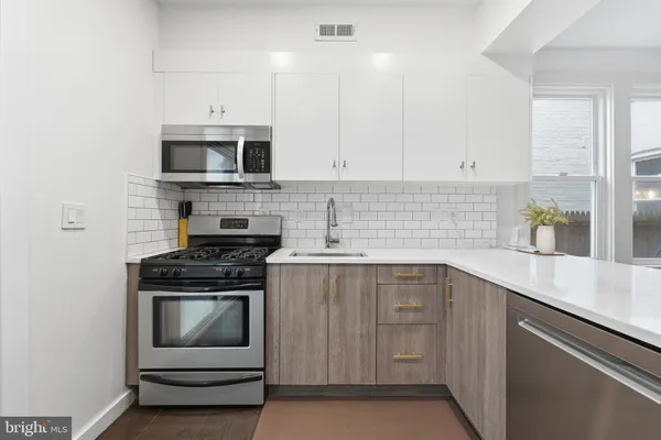a kitchen with cabinets stainless steel appliances and sink