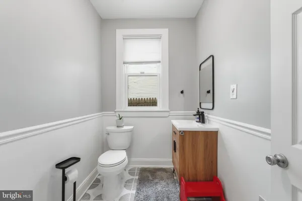 a bathroom with a sink vanity mirror and toilet